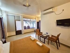 a living room with a bed and a table and chairs at Sea View Balcony room - Tide End Beach Villa in Pallipuram