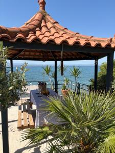 a gazebo with a bench and the ocean at Blue Nights Apartments Eretria in Eretria