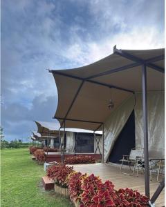 a row of tables and chairs under an umbrella at Tikumbar Glamping Pelaga in Plaga