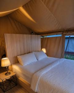 a bedroom with a bed in a tent at Tikumbar Glamping Pelaga in Plaga +14 photos