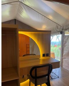 a desk in a tent with a table and a chair at Tikumbar Glamping Pelaga in Plaga