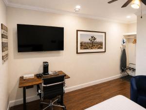 a room with a desk and a television on a wall at El Dorado Motel in Twain Harte