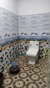 a bathroom with a toilet and birds on the wall at The Kedar Heights in Gupta Kāshi