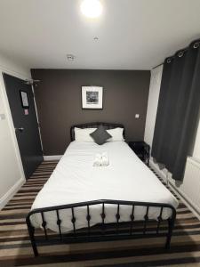 a bedroom with a bed with two shoes on it at TBH Hotel in Barking