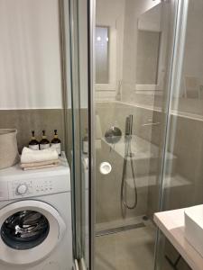 a bathroom with a washing machine and a shower at Blue Nights Apartments Eretria in Eretria +31 photos