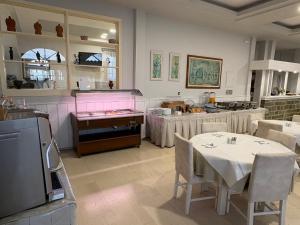 a dining room with a table and a kitchen at Zakros Beach hotel in Tolo