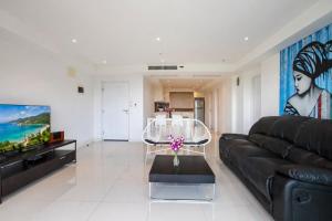 a living room with a black couch and a tv at Kata Hills Condo with Terrace & Sea View O910 in Ka Rorn +19 photos