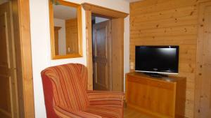 a living room with a television and a chair at Pension Elisabeth in Vent
