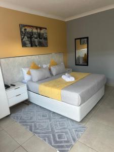 a bedroom with a large bed with yellow sheets at Chirute guest lodge in Randfontein +4 photos