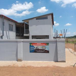 a building with a wall with a sign on it at Chirute guest lodge in Randfontein