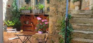 a patio with a table and flowers on a building at "Les Chacobins" - appart'étape avec Garage Vélos in La Réole