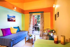 a living room with a blue couch and colorful walls at Haroula Apartments in Sidari