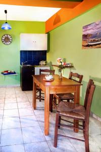 a kitchen with a wooden table and chairs in a room at Haroula Apartments in Sidari