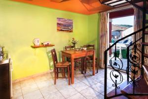 a dining room with a table and chairs in a room at Haroula Apartments in Sidari