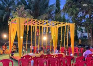 a table set up for an event with red chairs at Matoshree Green Garden Resort in Badlapur