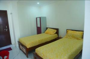 a bedroom with two beds with yellow sheets at Prime PG - Coliving Hostel in Hyderabad