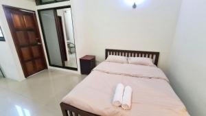 a bedroom with a bed with white slippers on it at My place 77 2 in Ban Khlong Khwang Klang