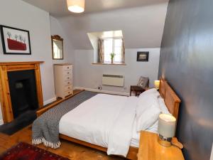 a bedroom with a large white bed and a window at Gamekeepers Cottage in Chillingham
