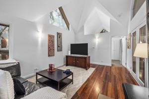 a living room with a couch and a tv at Lochiel Cottages - Dandenong Ranges Escape in Olinda