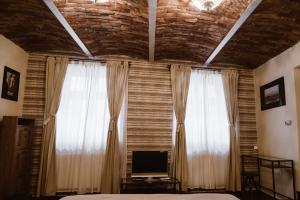 シビウにあるArhiva Loftのベッドルーム1室(窓2つ、ベッド1台、テレビ付)