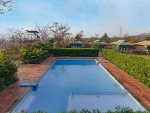 a large blue swimming pool in a yard at Nature Trails Durshet, Khopoli in Khopoli