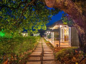 a walkway leading to a building under a tree at Nature Trails Durshet, Khopoli in Khopoli