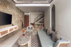a living room with a couch and a tv at Astera Resort & Spa Canggu by Ini Vie Hospitality in Canggu +52 photos