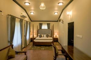 a bedroom with a bed and a table and chairs at Parisons Plantation Experiences by Abad in Mananthavady