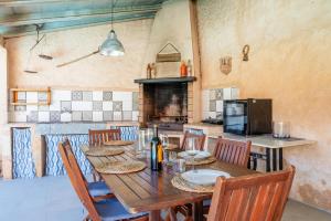 a kitchen with a wooden table with chairs and a stove at Cas Padri Teco in Ariany