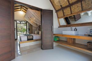 a bathroom with a sink and a bed in a room at Gili Air Bungalows in Gili Islands