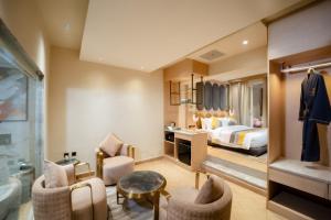 a hotel room with a bed and a desk and chairs at The Panache Kautilya in Patna