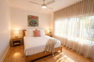 a bedroom with a bed and a large window at Ocean Views Byron Infused Bliss NEW in Encounter Bay