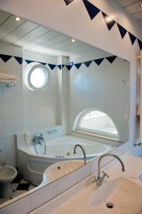 a bathroom with two sinks and a tub and a mirror at El Cid Campeador - Family Hotel in Rimini