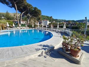 a large swimming pool with chairs and umbrellas at OndaMaris Tropea in Tropea