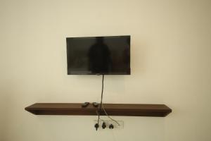 a flat screen tv hanging on a wall at Ruish City Kandy in Kandy
