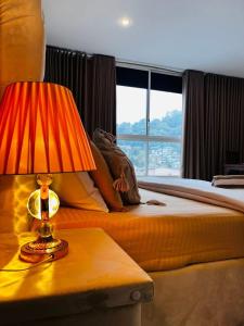 a bedroom with a bed and a lamp on a table at Ruish City Kandy in Kandy