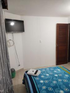 a room with a bed with a television on the wall at Fortaleza Diosa Chia in Chía