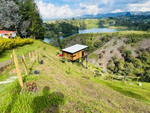 a small house on top of a hill with a lake at Cabaña MonteCristo in El Peñol +12 photos