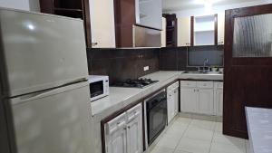 a kitchen with white cabinets and a stove top oven at Fortaleza Diosa Chia in Chía