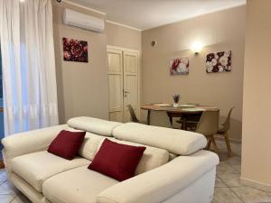 a living room with a white couch with red pillows at La casetta in Pontedera +6 photos