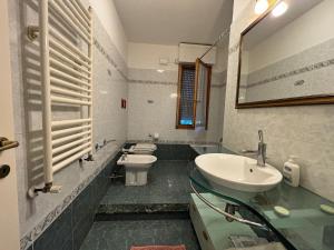 a bathroom with a sink and a toilet and a mirror at La casetta in Pontedera
