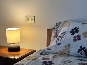a bed with a lamp on a table next to it at La casetta in Pontedera