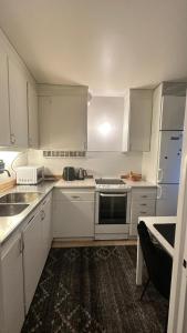 a white kitchen with white cabinets and a sink at kenneth's Home in Stockholm