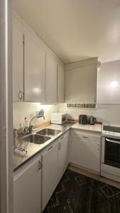 a kitchen with white cabinets and a sink at kenneth's Home in Stockholm +29 photos