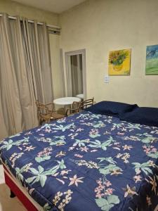 a bedroom with a bed with a blue blanket with flowers at Rosy flat térreo in Petrolina