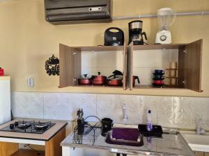 a kitchen with a counter with pots and pans at Rosy flat térreo in Petrolina