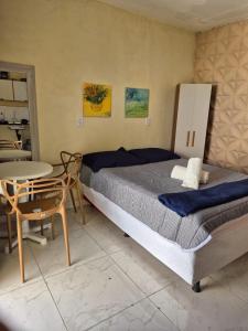 a bedroom with a large bed and a table at Rosy flat térreo in Petrolina +7 photos