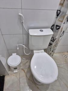 a bathroom with a white toilet and a sink at Rosy flat térreo in Petrolina