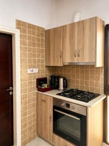 a kitchen with wooden cabinets and a stove top oven at Peyia traditional house in Paphos