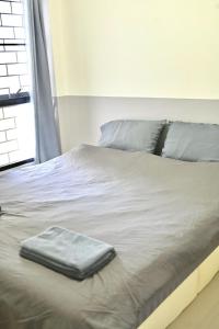 a bed with a suitcase sitting on top of it at บ้านอิงฟ้าแม่ฮ่องสอน in Ban Mai Ngae
